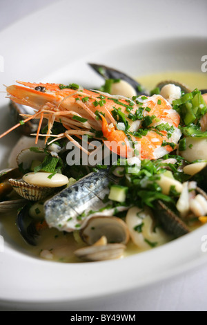 LEICHT POCHIERT AUSWAHL AN FISCH UND MEERESFRÜCHTEN MIT BUTTERBOHNEN UND KRÄUTERN IM NEWPORT RESTAURANT YACHTAUSRÜSTER. Stockfoto