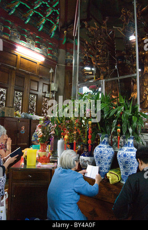 Eine alte Frau lesen buddhistische Schrift im Naputuo Tempel, Xiamen Stockfoto