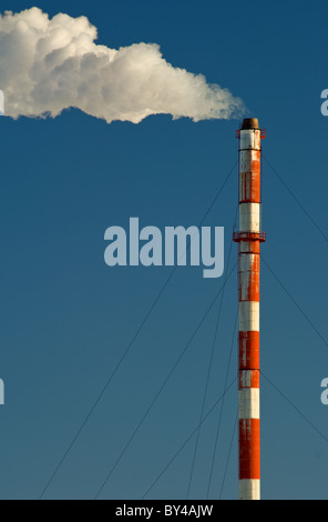 Rauch, Gas und Dampf Wogen aus einem Schornstein vor blauem Himmel. Stockfoto