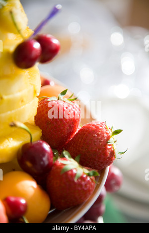 Nahaufnahme von saftigen Erdbeeren und Kirschen auf Teller mit in Scheiben geschnittenen Ananas in der Nähe von Stockfoto