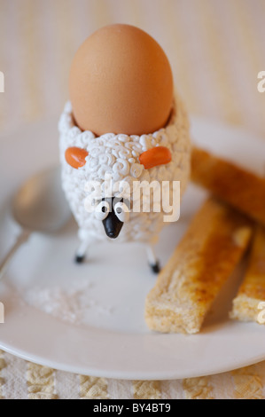 Kinder Schaf Eierbecher mit gekochtem Ei und Butter Soldaten Stockfoto