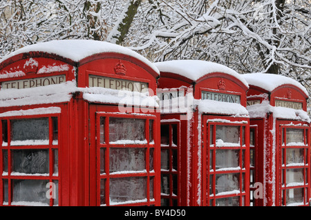 drei schneebedeckte rote Telefonzellen Stockfoto