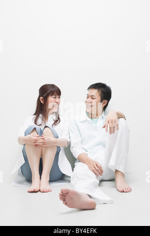 Junges Paar sitzen nebeneinander Stockfoto