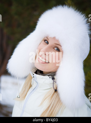 Porträt von frischen Frau in weißem Fellmütze mit Ohrenklappen und Blick in die Kamera Lächeln Stockfoto