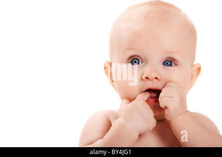 Entzückende Baby halten ihre Finger im Mund und beiseite mit Blick auf weißem Hintergrund Stockfoto