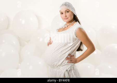 Porträt von modischen Weibchen ihren schwangeren Bauch zu berühren und auf der Suche zur Seite Stockfoto