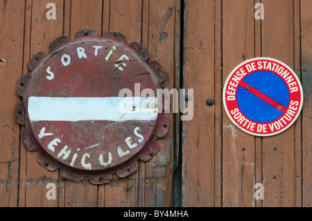 Französische "Fahrzeug beenden" und "No Parking" Zeichen auf einem Garagentor in einem französischen Dorf. Stockfoto