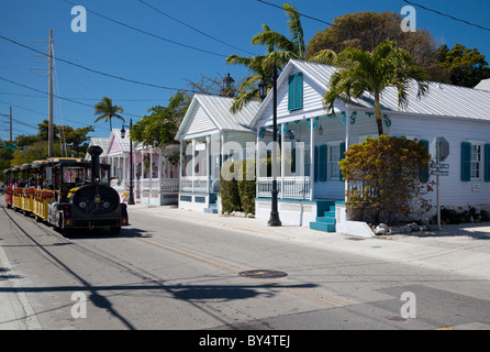 Der Conch Tour Zug geht eine Reihe von hübschen kleinen Hütte Stil Häuser in Key West, Florida, USA Stockfoto