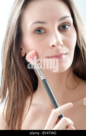 Eine junge Frau hält einen Rouge Stockfoto