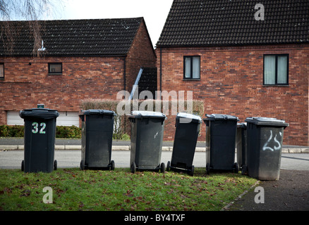 Eine Reihe von grauen Kunststoff Wheelie Lagerplätze erwartet Entleerung durch Müllmänner in einer Straße in Redditch, Worcestershire, UK Stockfoto