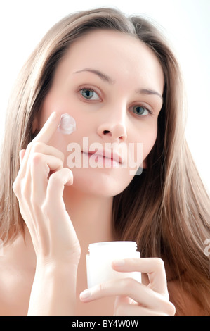 Frau Auftragen der Creme auf Gesicht Stockfoto