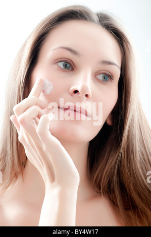Frau Auftragen der Creme auf Gesicht Stockfoto