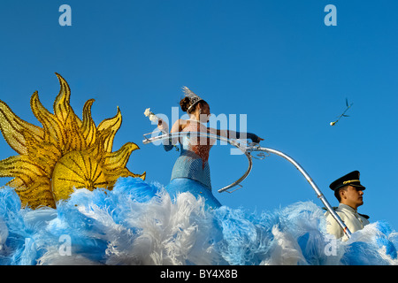 Eine kolumbianische Mädchen wirft Rosen vom oberen Rand der allegorischen Schwimmer während der Karneval in Barranquilla, Kolumbien. Stockfoto