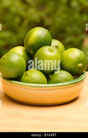 Nahaufnahme der Limetten (Citrus latifolia) eine keramische Schüssel auf natürlichen Hintergrund Stockfoto