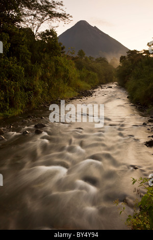 Sonnenaufgang am Fluss Tabacon und aktivste Vulkan Costa Ricas der Vulkan Arenal in Arenal Nationalpark, Alajuela, Costa Rica. Stockfoto