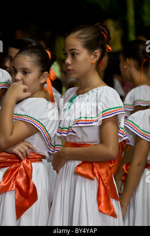 Mädchen in traditioneller Kleidung warten nervös, während Unabhängigkeitstag feiern in La Fortuna, Costa Rica zu tanzen. Stockfoto