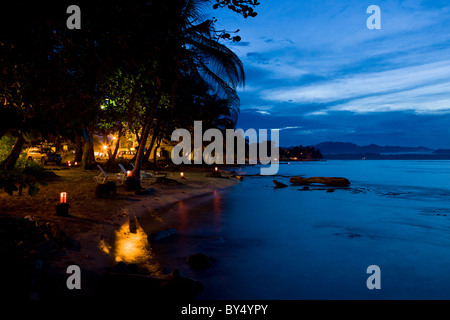 Dämmerung und Kerze beleuchtet Strand vor dem Salsa Brava Restaurant benannt nach der berühmten Surf-Pause in Puerto Viejo, Costa Rica. Stockfoto