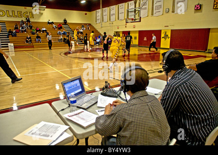 Campus Radiosprecher (rechts) bietet einen laufenden Kommentar auf einem Basketball-Spiel in der College-Turnhalle. Stockfoto