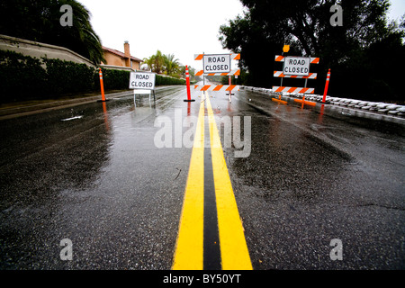 Drei-Stopp-Schilder warnen Verkehr weg von einer verwaschen Straße nach Starkregen in Südkalifornien. Stockfoto