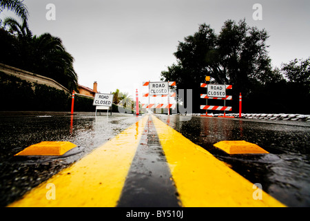 Drei-Stopp-Schilder warnen Verkehr weg von einer verwaschen Straße nach Starkregen in Südkalifornien. Stockfoto