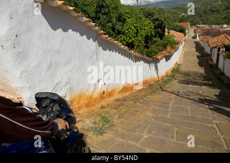 Mann auf dem Moped fahren auf einer kolonialen Straße von Barichara, Santander, Kolumbien Stockfoto