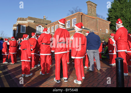 Leute, gekleidet in Santa-Outfits warten zu Beginn der Jingle Bell Jog Volkslauf Stockfoto