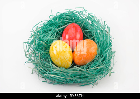 Osternest mit drei farbigen Eiern Stockfoto