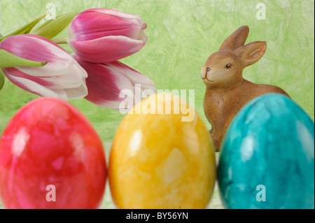 Osterhase mit Tulpen und roten, gelben und grünen Ei Stockfoto