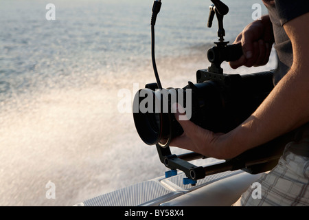 Ein Kameramann filmt auf einem Motorboot Stockfoto