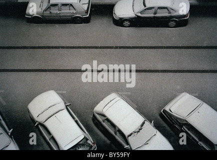 Autos im Schnee auf einer Straße bedeckt Stockfoto