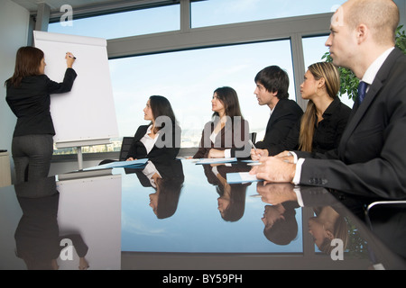Business Training wo sitzen Gruppe von Personen an einem Tisch mit dem Lehrer steht man vor einem Flip-chart Stockfoto