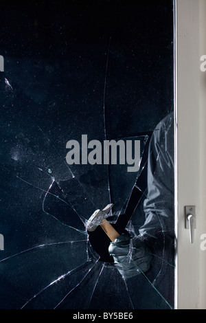 Ein Verbrecher, der Einbruch in ein Fenster, Fokus auf Seite Stockfoto