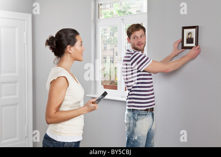 Ein paar Aufhängen eines Bilderrahmens in ihrer neuen Heimat Stockfoto