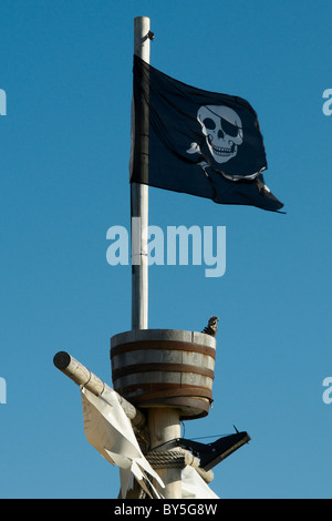 Piratenflagge Jolly Roger auf einem Mast mit einem Crows nest Stockfoto