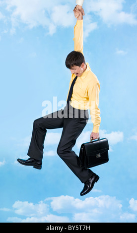 Vertikales Bild des Kaufmanns in Schwierigkeiten an helfende hand auf Hintergrund des Himmels Stockfoto
