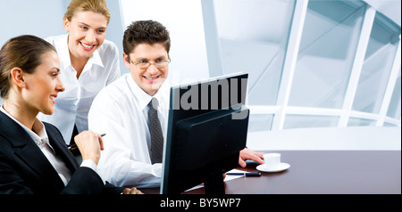 Team von drei Geschäftsleute, die am Monitor des Computers im Büro Stockfoto