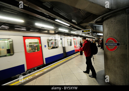 Unterirdische U-Bahn-Station Westminster Circle und District Line Plattform mit Mann liest Zeitung, London, England, UK Stockfoto