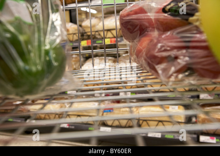 Blick von einem Einkaufswagen mit Obst und Gemüse in den Brot-Gang in eine britische Supermarktkette Stockfoto