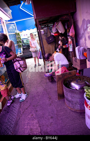 Alte chinesische Mann reparieren Schuhe auf der Straße die altmodische Art und Weise in Hong Kong, China Stockfoto