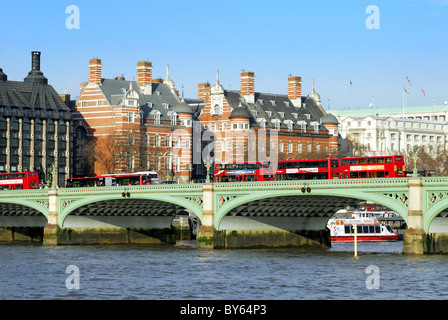 Roten Londoner Busse auf Westminster Bridge mit Themse im Vordergrund Stockfoto