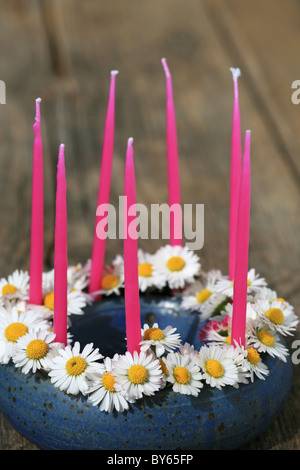 Kranz aus Margeriten mit rosa Kerzen Stockfoto