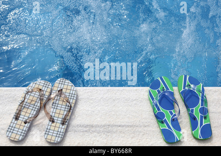 Flip Flops neben einem Schwimmbad Stockfoto