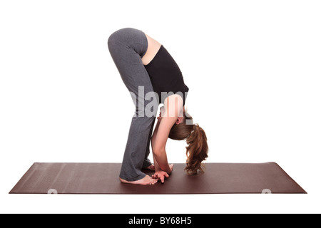 Isolierte Studioaufnahme einer Fit kaukasischen Frau die Stoffpuppe Yogaposition auf eine Gymnastikmatte halten. Stockfoto