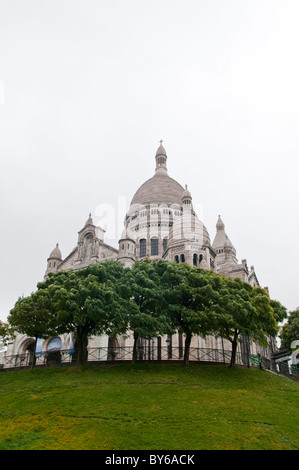 PARIS, Frankreich – die Basilika Sacré-Cœur in Montmartre erhebt sich majestätisch auf dem höchsten Punkt von Paris. Diese berühmte Kathedrale mit weißer Kuppel, die 1914 fertiggestellt wurde, bietet einen atemberaubenden Blick auf die Stadt. Die Basilika ist ein bedeutendes religiöses und kulturelles Wahrzeichen und zieht Besucher mit ihrer atemberaubenden Architektur und ruhigen Inneneinrichtung an. Stockfoto