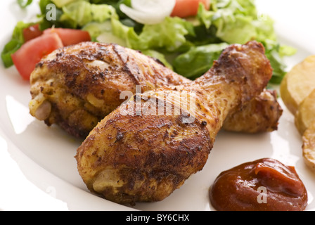 Grill-Hähnchenschenkel mit mit Salat als Closeup auf einem weißen Teller Stockfoto