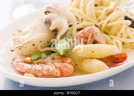 Spaghetti mit Meeresfrüchten und Spargel Speeren als Closeup auf einem weißen Teller Stockfoto