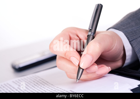 Foto der grauen Feder in der Hand über Dokument am Arbeitsplatz Stockfoto