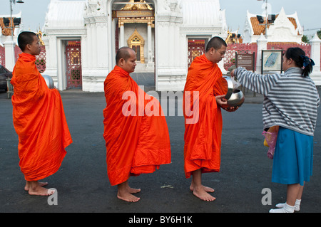 Mönch Almosen empfangen, von einem Mädchen vor Wat Benjamabophit, Bangkok, Thailand Stockfoto