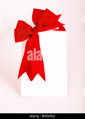 Schöne rote Schleife über leere Grußkarte, Ferienkonzept Stockfoto