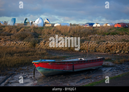 Beiboot im Wattenmeer mit umgedrehten Jollen im Hintergrund. Stockfoto